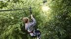 Girl in grey jumper on zip line in blog about some of the best zip wires in the UK